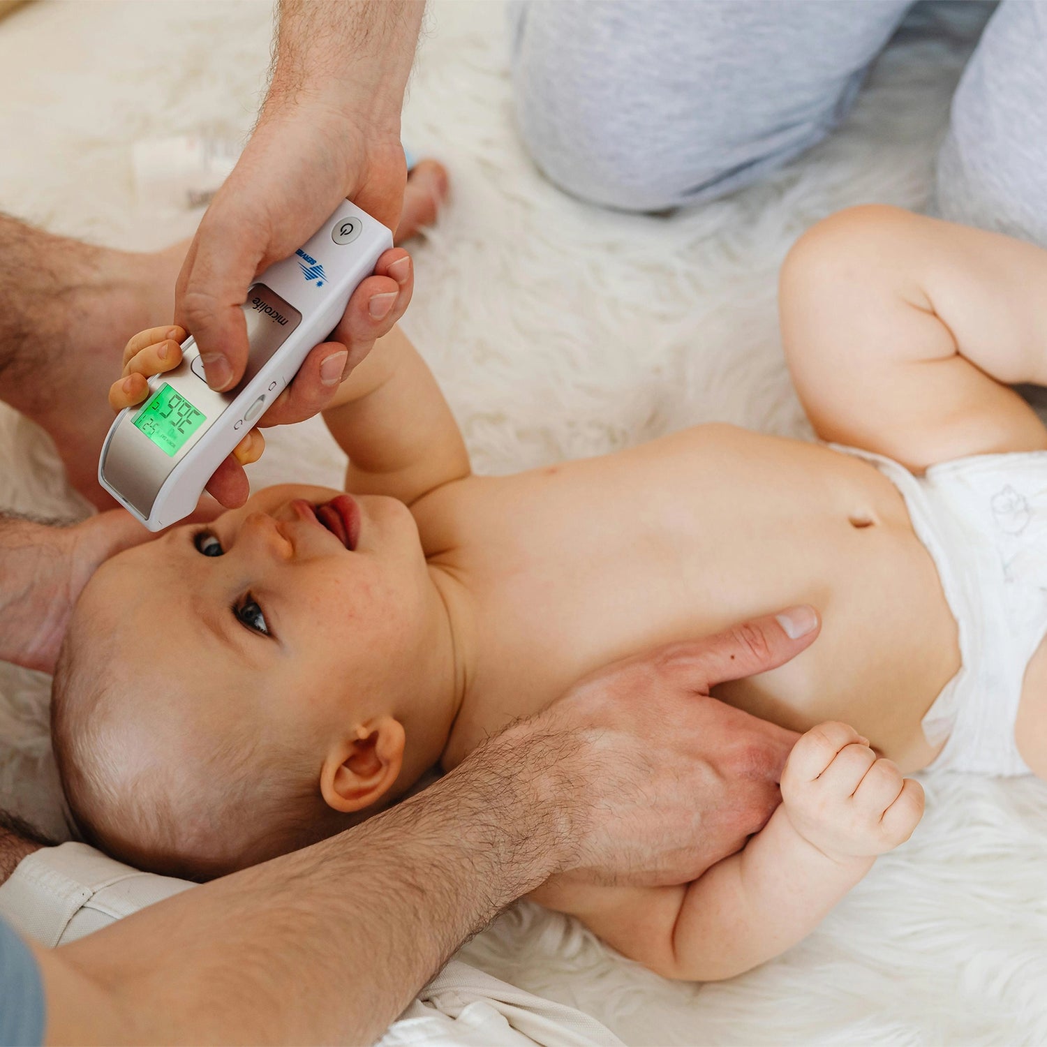 parents utilisent un thermomètre sur le bébé